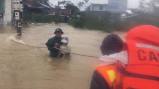 Tại những chỗ ngập sâu, nước chảy siết lực lượng công an phải đu dây để đưa người dân bị ngập lụt đến nơi an toàn.