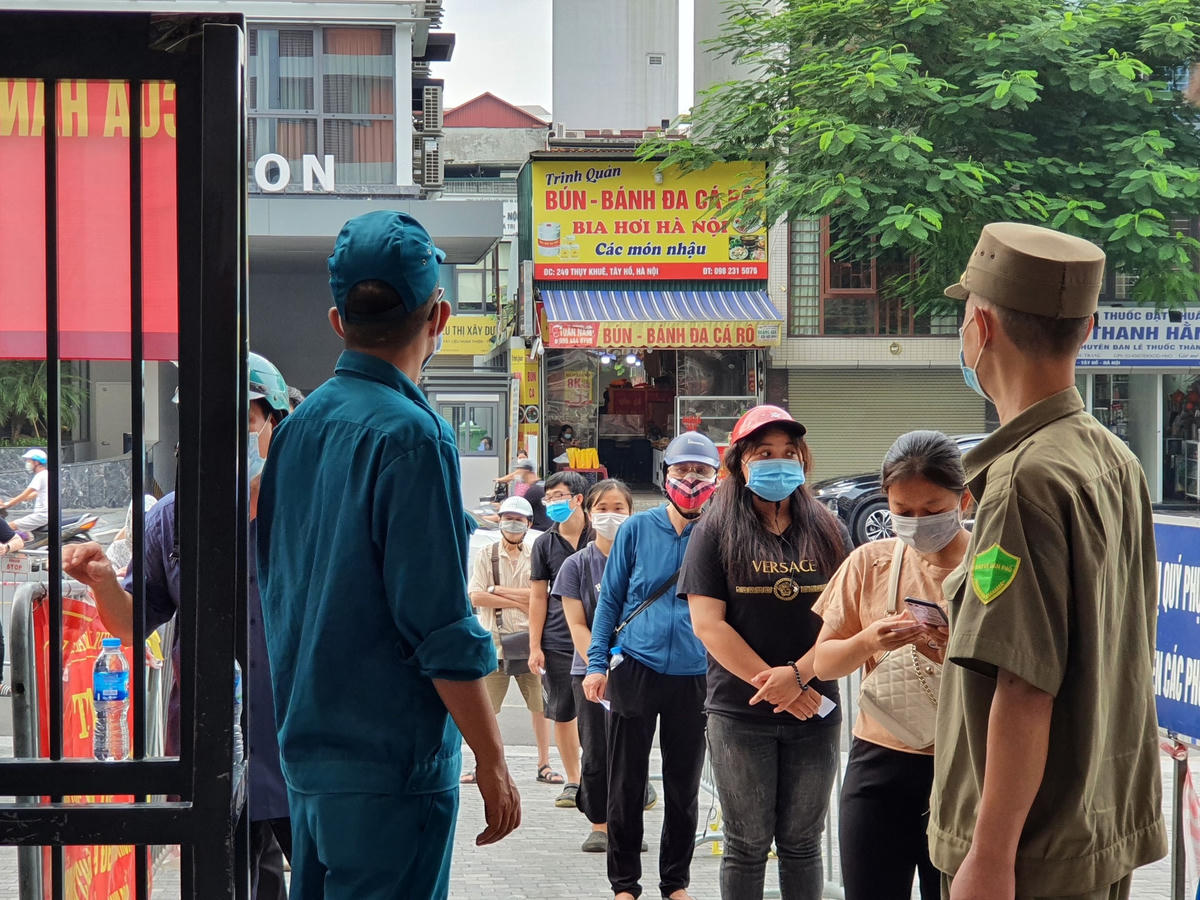 Lực lượng chức năng liên tục nhắc nhở người dân thực hiệp xếp hàng và đảm bảo trật tự.