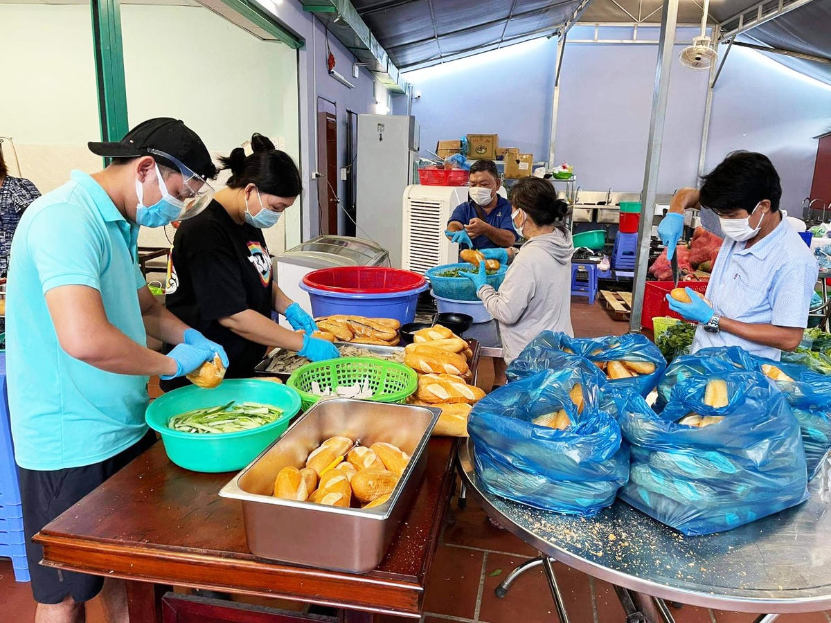 Các thành viên của Bếp “Happy 0 đồng” chuẩn bị các suất ăn gửi đến tuyến đầu chống dịch và nhân dân trong khu phong tỏa, cách ly.