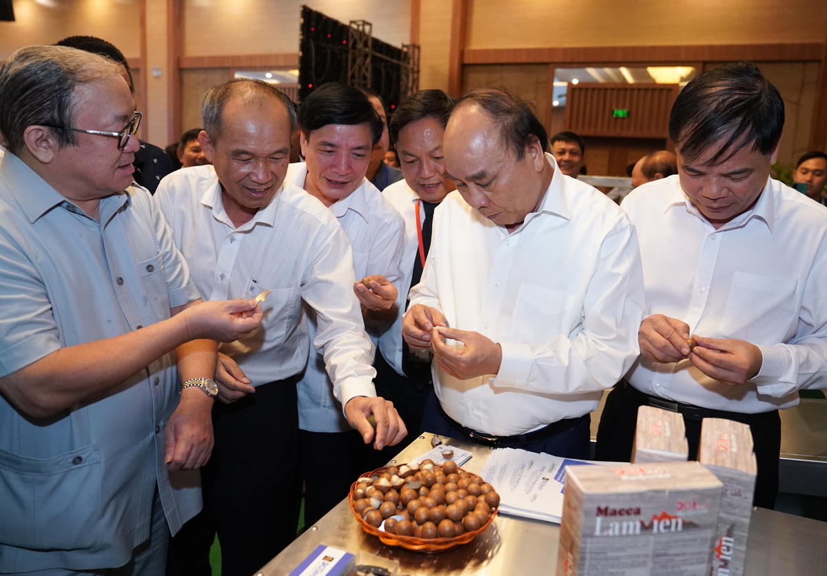 Thủ tướng Nguyễn Xuân Phúc tham quan khu trưng bày sản phẩm được chế biến từ hạt mắc ca. Ảnh: VGP.