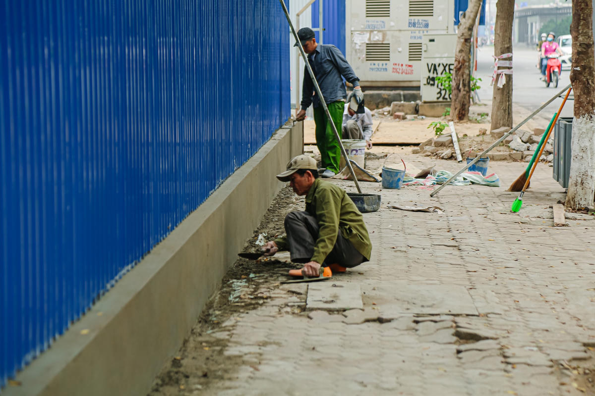Một công nhân đang thi công hàng rào này cho hay, phần móng hàng rào được đào sâu 40 cm xuống dưới vỉa hè. Móng của hàng rào được đổ bê tông, có cốt thép rất kiên cố. Tổng chiều dài hàng rào là 90 m dọc theo đường Lê Văn Lương và 40 m nằm trên vỉa hè đường Lê Văn Thiêm.