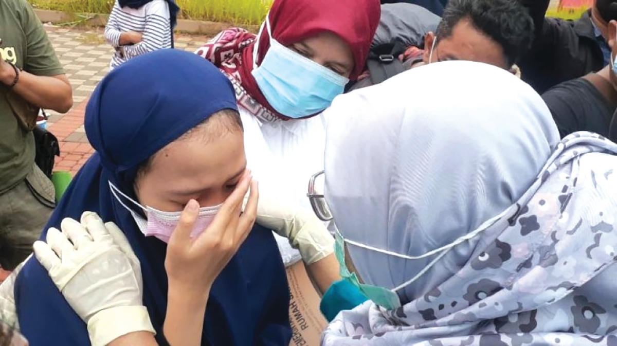 Bác sĩ an ủi một cô bé ở tỉnh Banten (Indonesia) mất mẹ do đại dịch. Nguồn: Kompas.