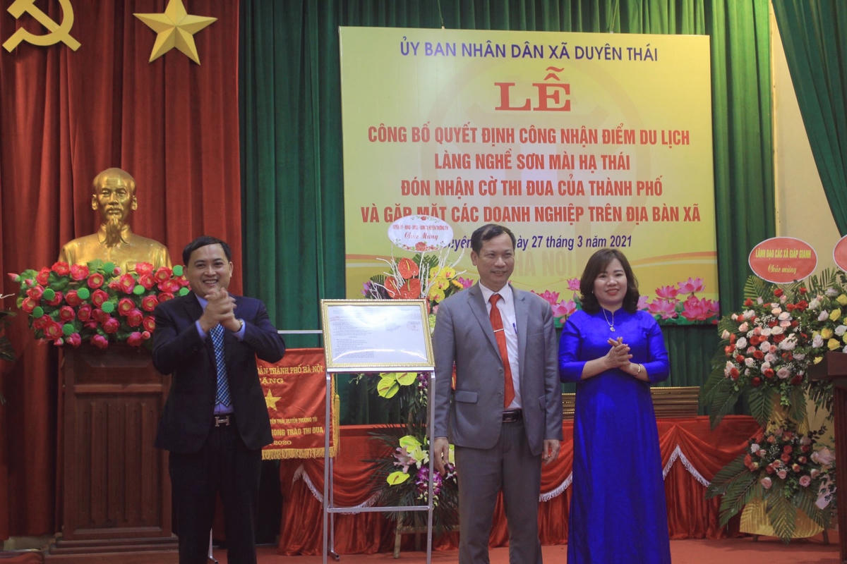 Ông Bùi Công Thản, Phó Chủ tịch UBND huyện Thường Tín trao quyết định công nhận điểm du lịch làng nghề sơn mài Hạ Thái cho lãnh đạo UBND xã Duyên Thái.  