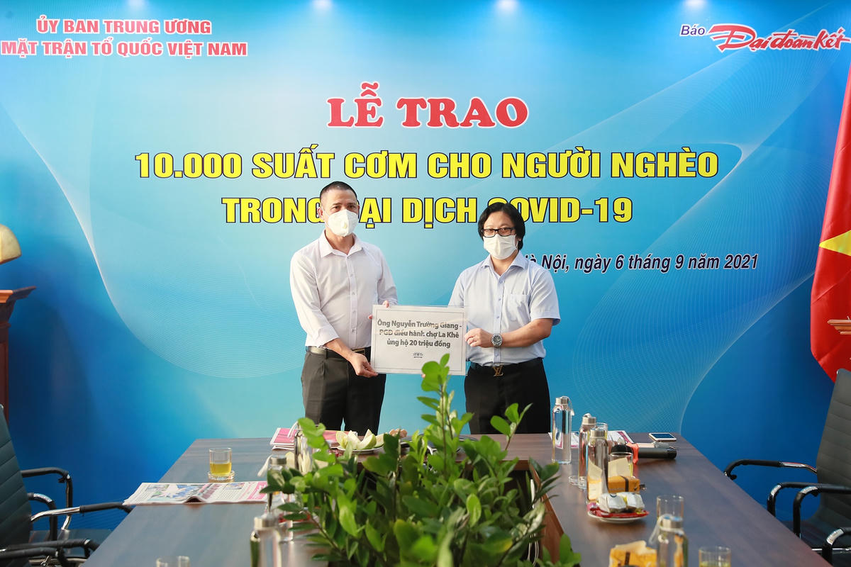 Quyền Tổng Biên tập Lê Anh Đạt nhận bảng tượng trưng tiền hỗ trợ chương trình từ ông Nguyễn Trường Giang, Phó Giám đốc Điều hành chợ La Khê. Ảnh: Quang Vinh.