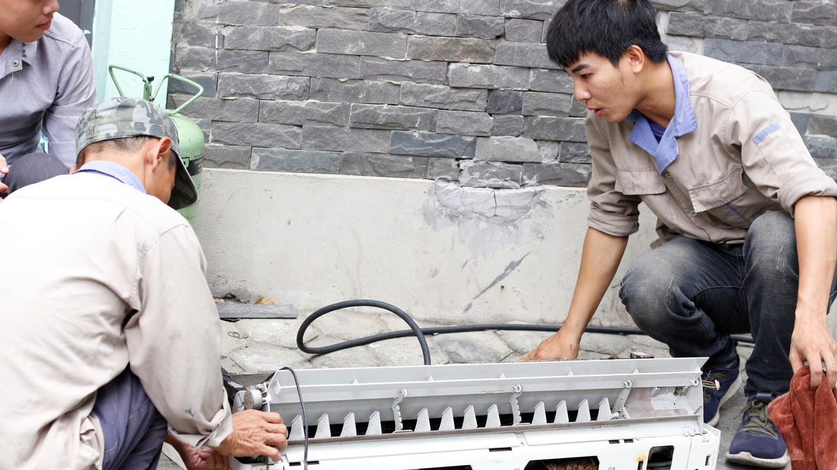 Chú Hùng, 45 tuổi, đồng nghiệp của anh Đức đang vệ sinh vỏ nhựa điều hòa.