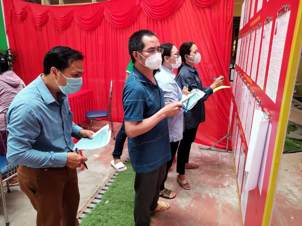 Cử tri nghiên cứu tiểu sử, chương trình hành động của các ứng viên đại biểu Quốc hội khóa XV và đại biểu HĐND các cấp trước khi bỏ phiếu.