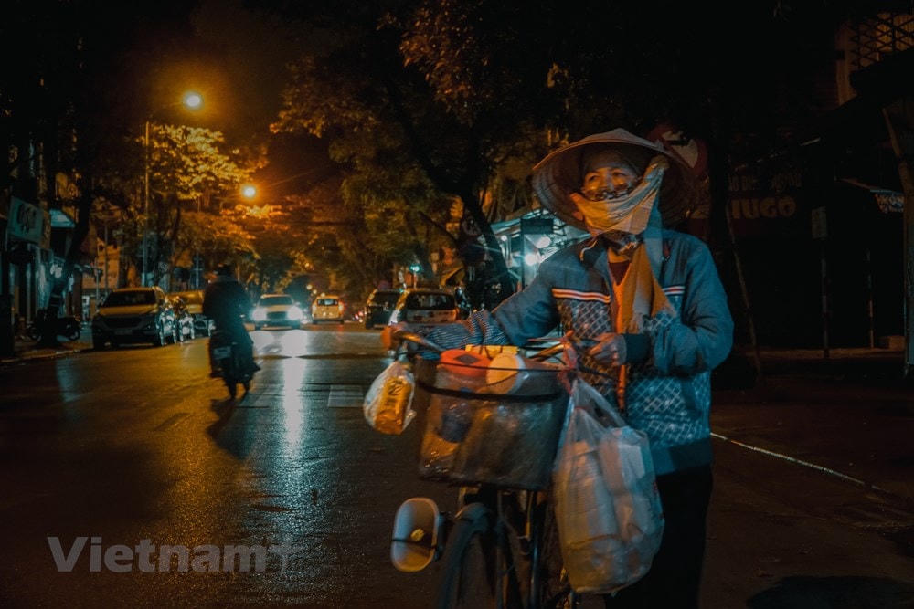 Gánh nặng vất vả kiếm sống đè trên đôi vai người lao động nghèo mỗi khi đêm xuống. Trời càng lạnh, vất vả, cực nhọc lại tăng thêm gấp nhiều lần, nhưng họ vẫn trắng đêm mưu sinh… (Ảnh: Minh Hiếu/Vietnam+).