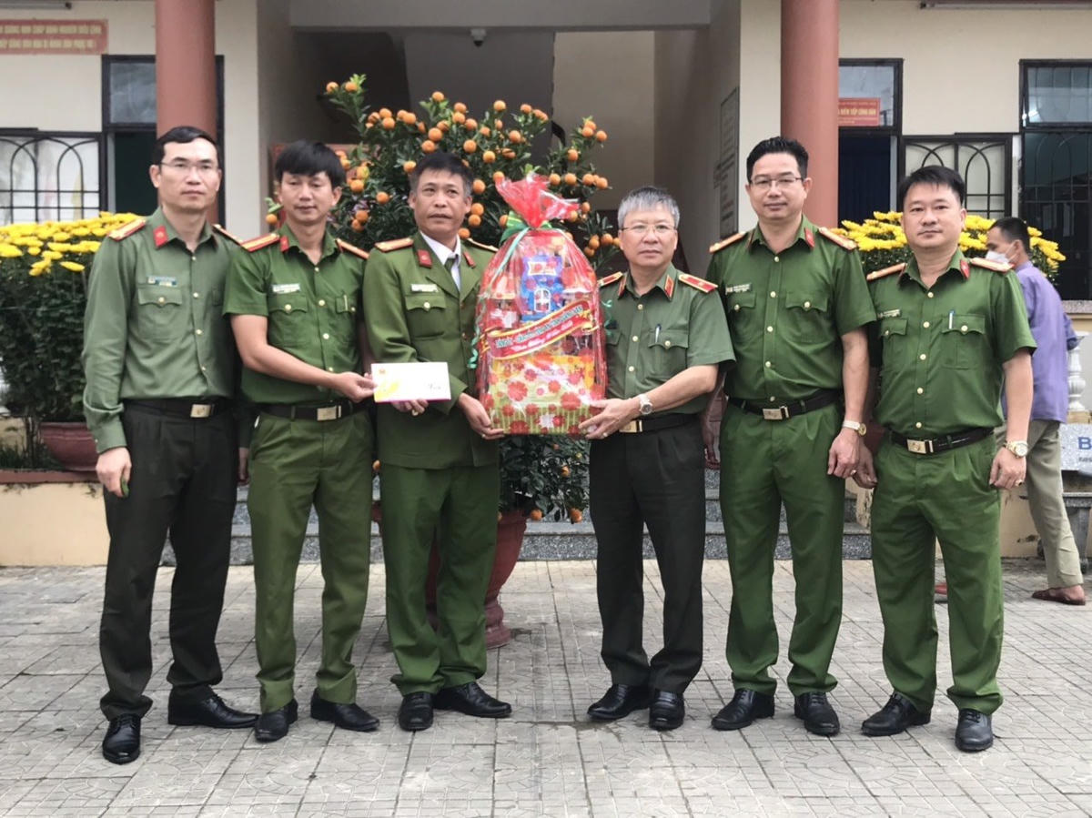 Thiếu tướng Nguyễn Đức Dũng (thứ 3 từ phải qua) tặng quà Tết cho Công an phường Trường Xuân, TP Tam Kỳ.