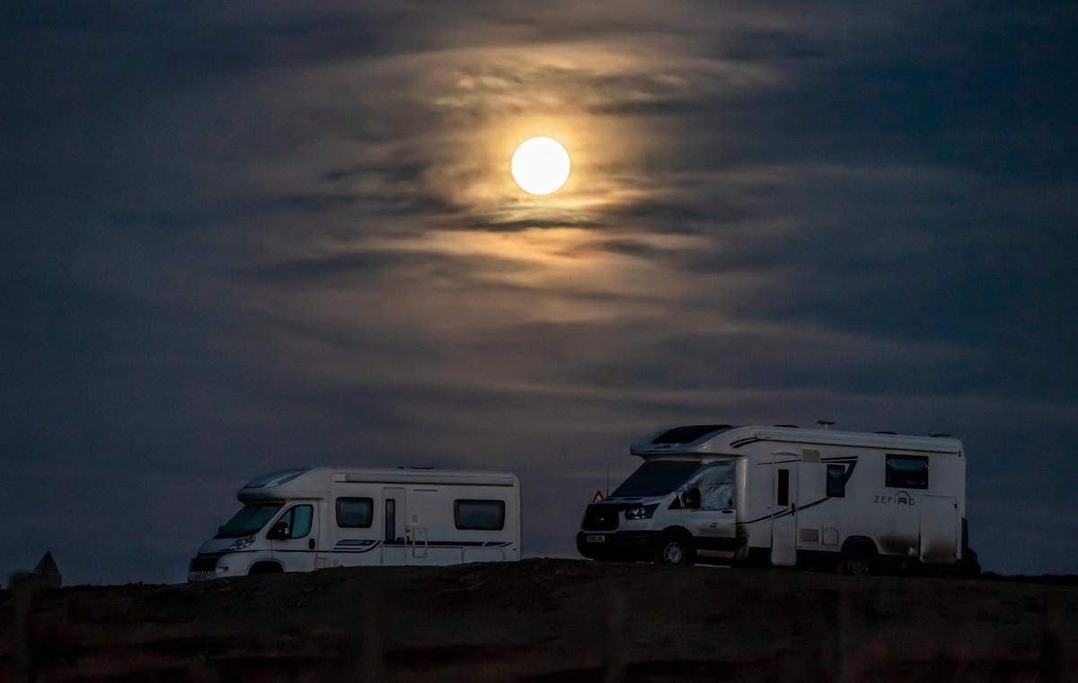 Mặt Trăng lặn sau một chiếc xe tải đậu trong công viên quốc gia North York Moors ở Yorkshire. Ảnh: Danny Lawson / PA.