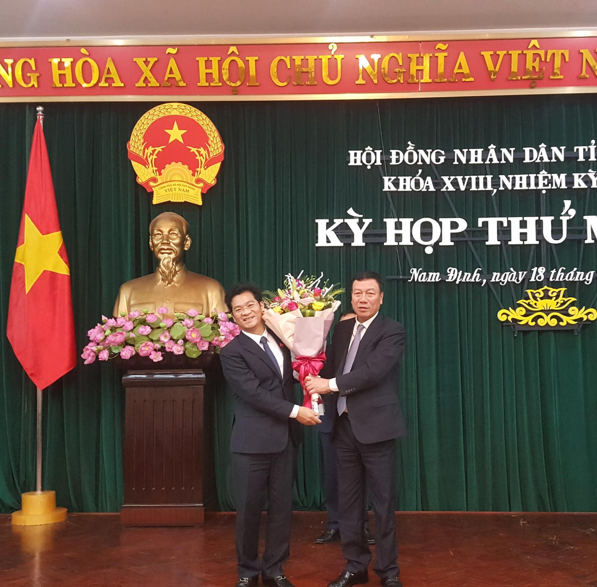 Tân Phó Chủ tịch UBND tỉnh Nam Định Trần Anh Dũng (bên trái) nhận hoa chúc mừng từ Bí thư Tỉnh ủy Đoàn Hồng Phong.