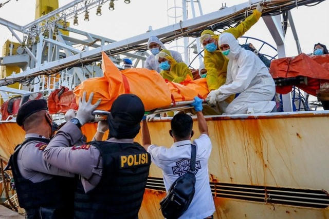 Thi thể thuyền viên Indonesia được đưa xuống khỏi tàu cá Trung Quốc (Ảnh: AFP).