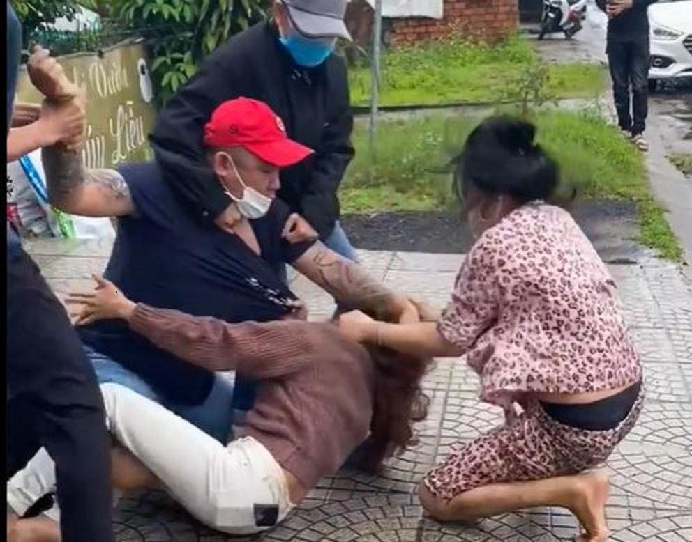 Người phụ nữ bị đánh trên lề đường. (Ảnh cắt clip)
