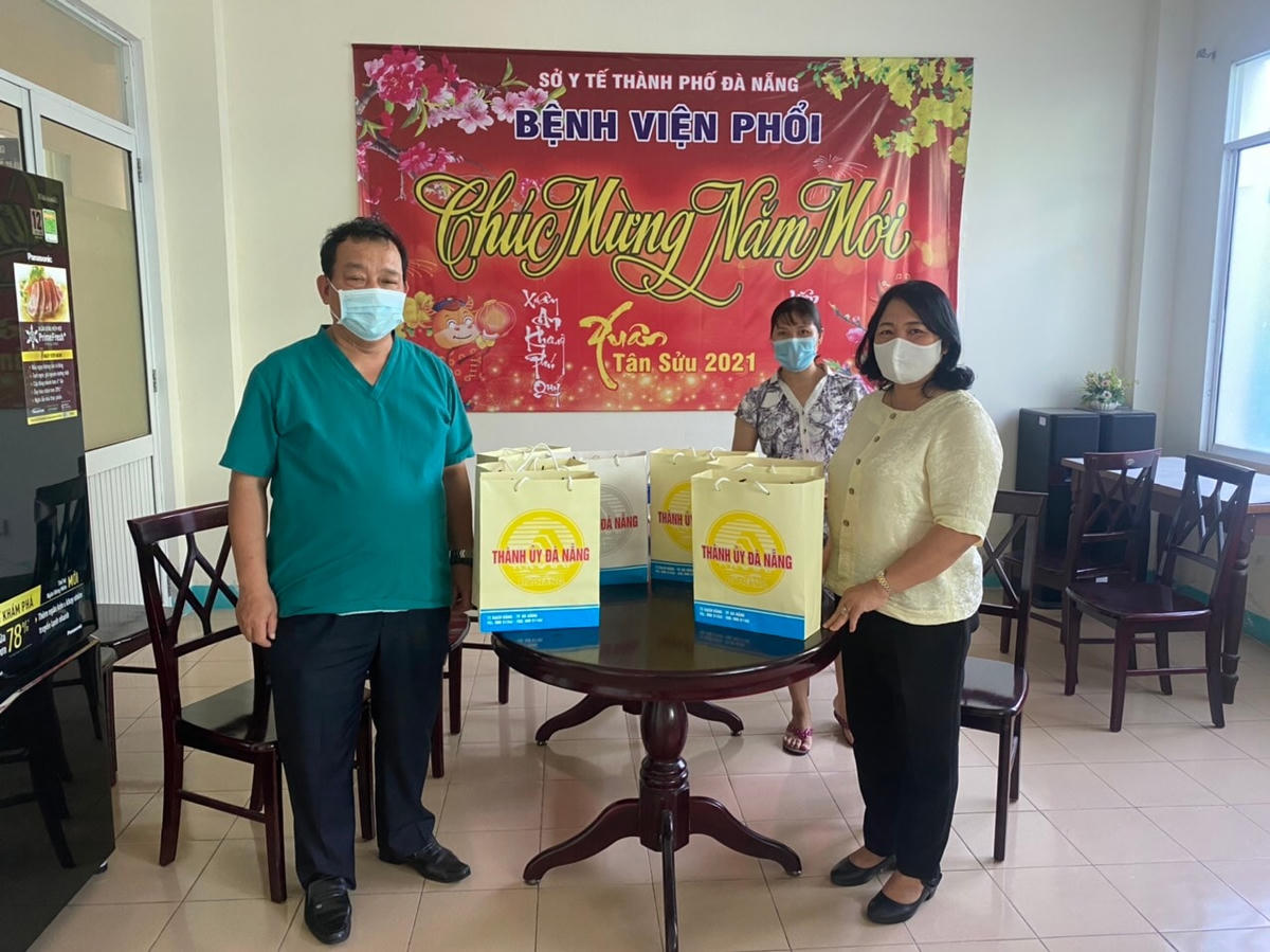 Bác sỹ Lê Thành Phúc (trái), thay mặt các bệnh nhi mắc Covid-19 đang điệu trị ở bệnh viện, nhận quà nhân ngày Quốc tế thiếu nhi 1/6 từ đại diện Thành ủy Đà Nẵng