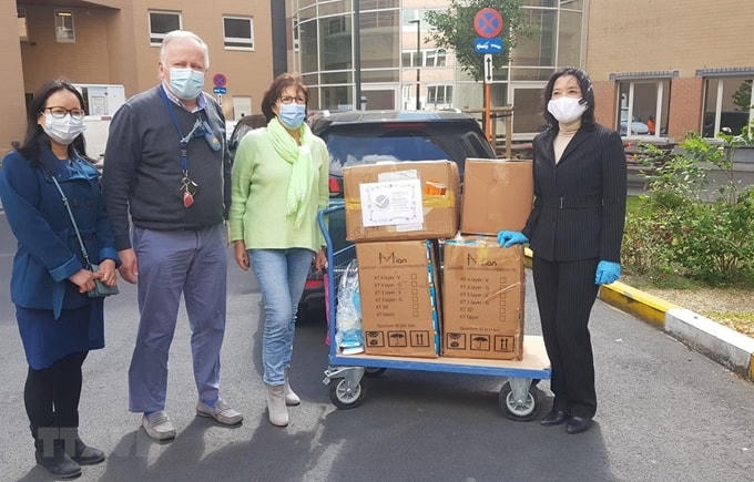 Chị Nguyễn Thị Minh Liên tặng 10.000 khẩu trang y tế cho Bệnh viện Saint Pierre tại Brussels. Ảnh: TTXVN.
