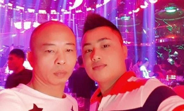 Tiến "trắng" (phải) chụp ảnh cùng bố nuôi.