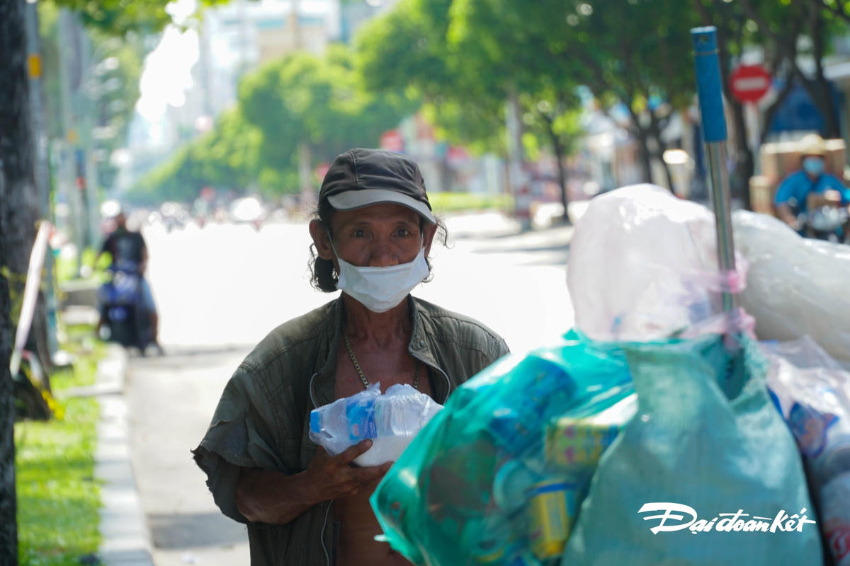 Người đàn ông với đôi mắt sâu hoắm vì cơ cực vui mừng khi cầm hộp cơm trên tay.