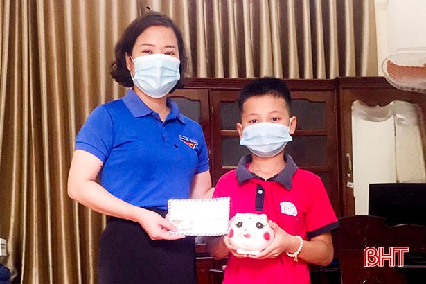 Chủ tịch Hội đồng đội huyện Đức Thọ Lê Thị Huyền Trang tiếp nhận tiền hỗ trợ Quỹ phòng, chống Covid-19 từ em Đinh Sỹ Phước. 