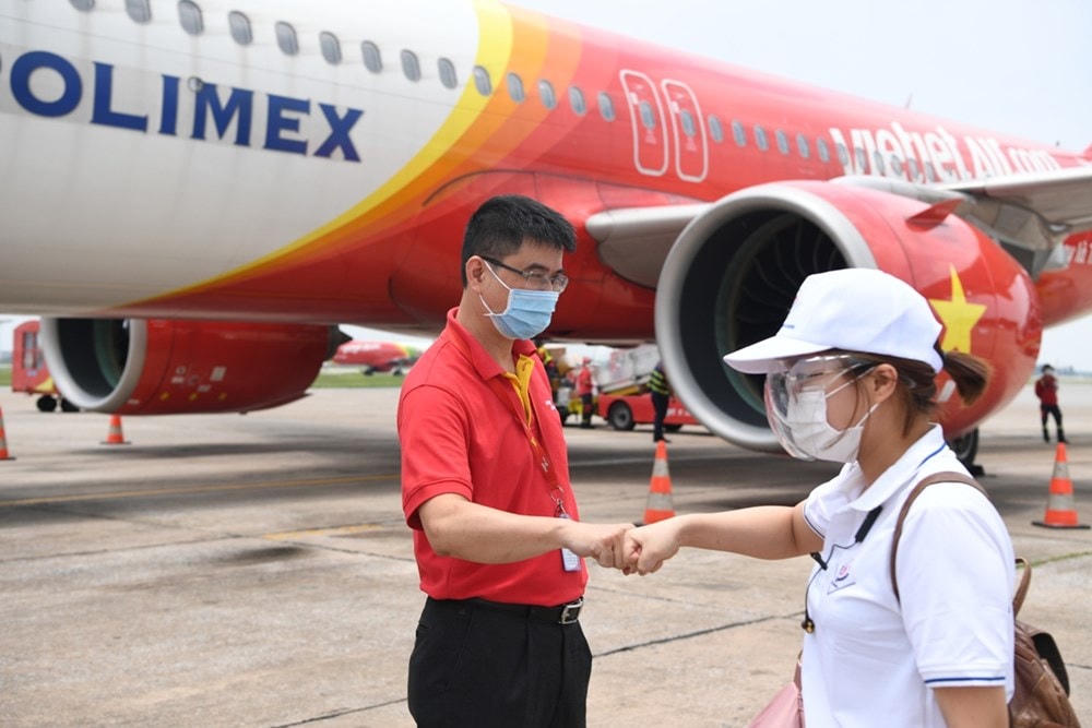 Niềm tin đẩy lùi dịch bệnh hiện rõ trên quyết tâm của nhân viên y tế và Vietjet. (Ảnh: CTV/Vietnam+).
