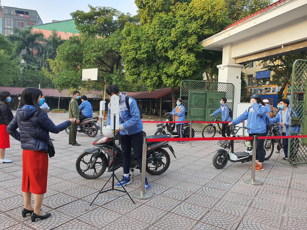 Học sinh Trường THPT Cầu Giấy được đó thân nhiệt trước khi vào trường học. 