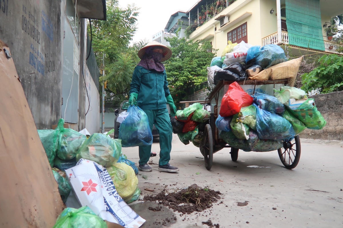 Công nhân Công ty môi trường JUDENCO thu gom rác thải sinh hoạt trong các khu dân cư.