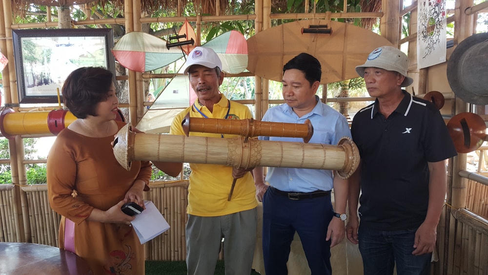 Nghệ nhân Trần Thúc Loan (Thái Bình) giới thiệu ống sáo độc đáo do mình chế tác.