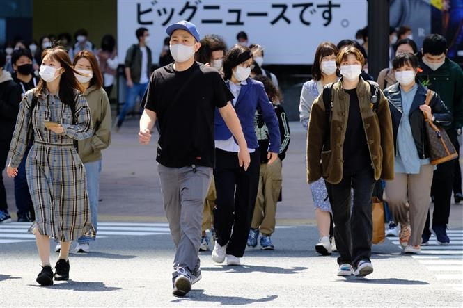 Người dân di chuyển trên phố ở Tokyo, Nhật Bản. (Ảnh: AFP/TTXVN).