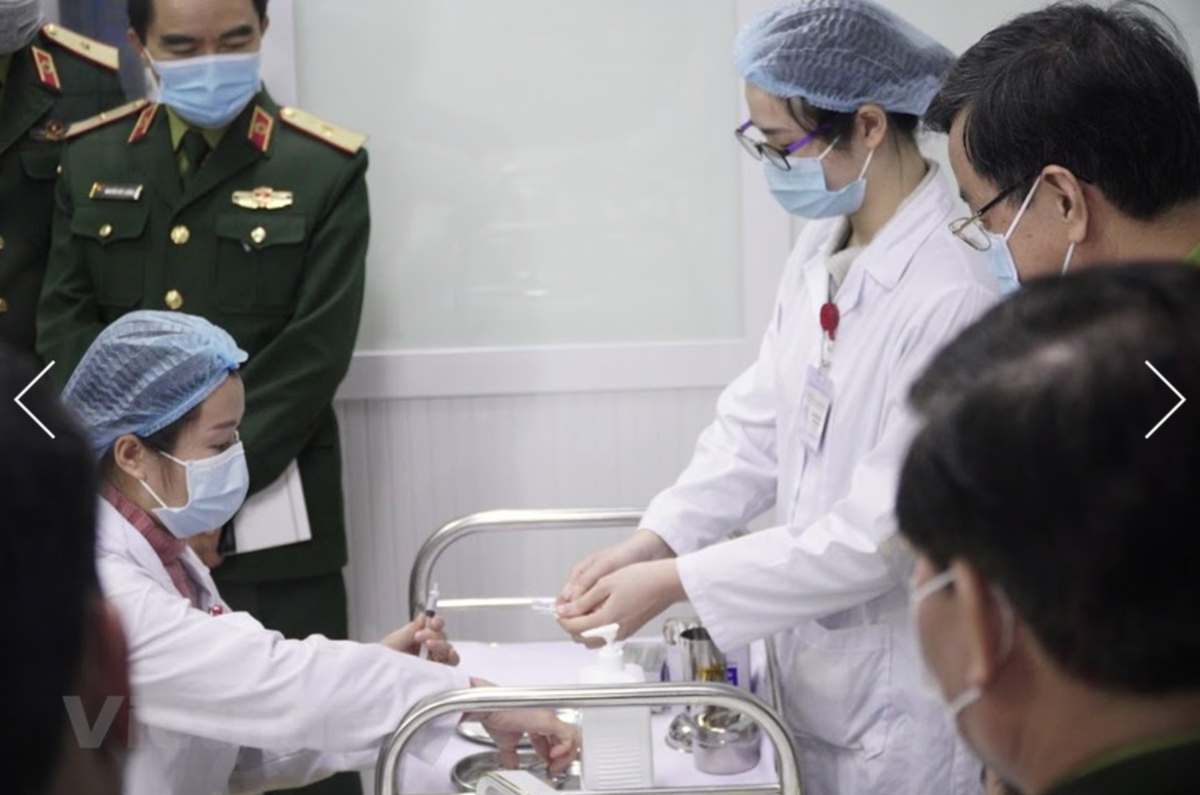 Các bác sĩ chuẩn bị mũi tiêm thử nghiệm vaccine phòng Covid-19. (Nguồn: Vietnam+).