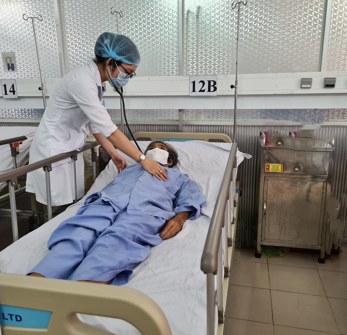 Bác sĩ thăm khám bệnh nhân sau phẫu thuật.