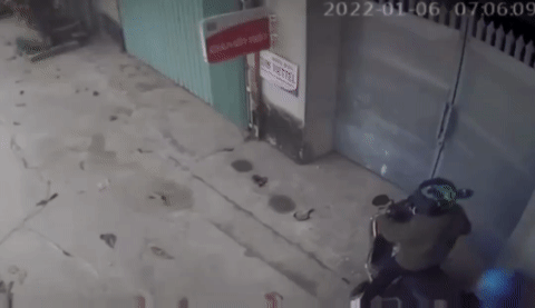 Người phụ nữ điều khiển xe máy phóng đi trong khi cậu con trai rớt lại phía sau (Ảnh cắt từ clip).  