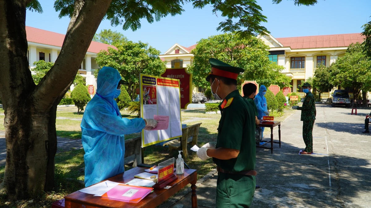 Cán bộ, chiến sĩ đang làm nhiệm vụ tại khu cách ly nhận phiếu bầu cử.