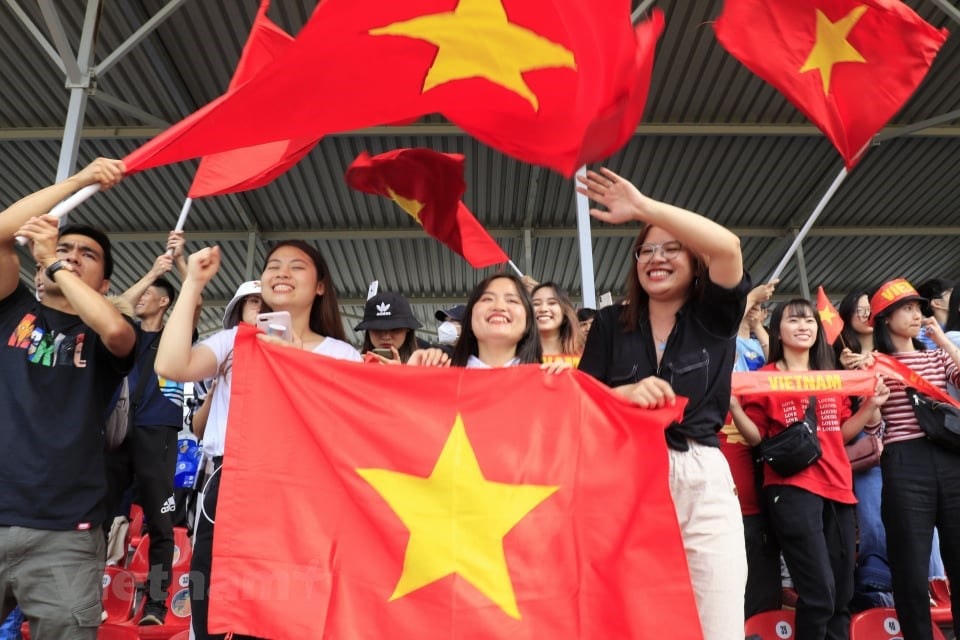 Người dân cổ vũ nhiệt tình cho đội tuyển Việt Nam. (Ảnh: Trần Hiếu/Vietnam+).
