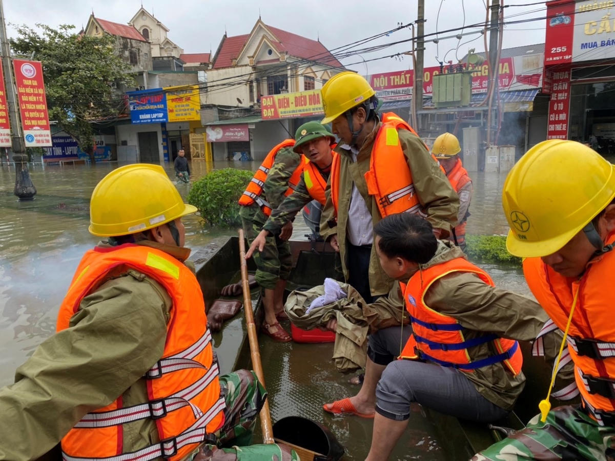 Đoàn công nhân Điện lực Thành Phố và phóng viên Đài, Báo tham gia đóng điện cho nhân dân sau lũ lụt.