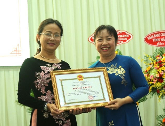 Bà Thái Thu Sương, Chủ tịch Ủy ban MTTQ Việt Nam tỉnh Hậu Giang (bìa phải) trao Bằng khen cho các cá nhân.
