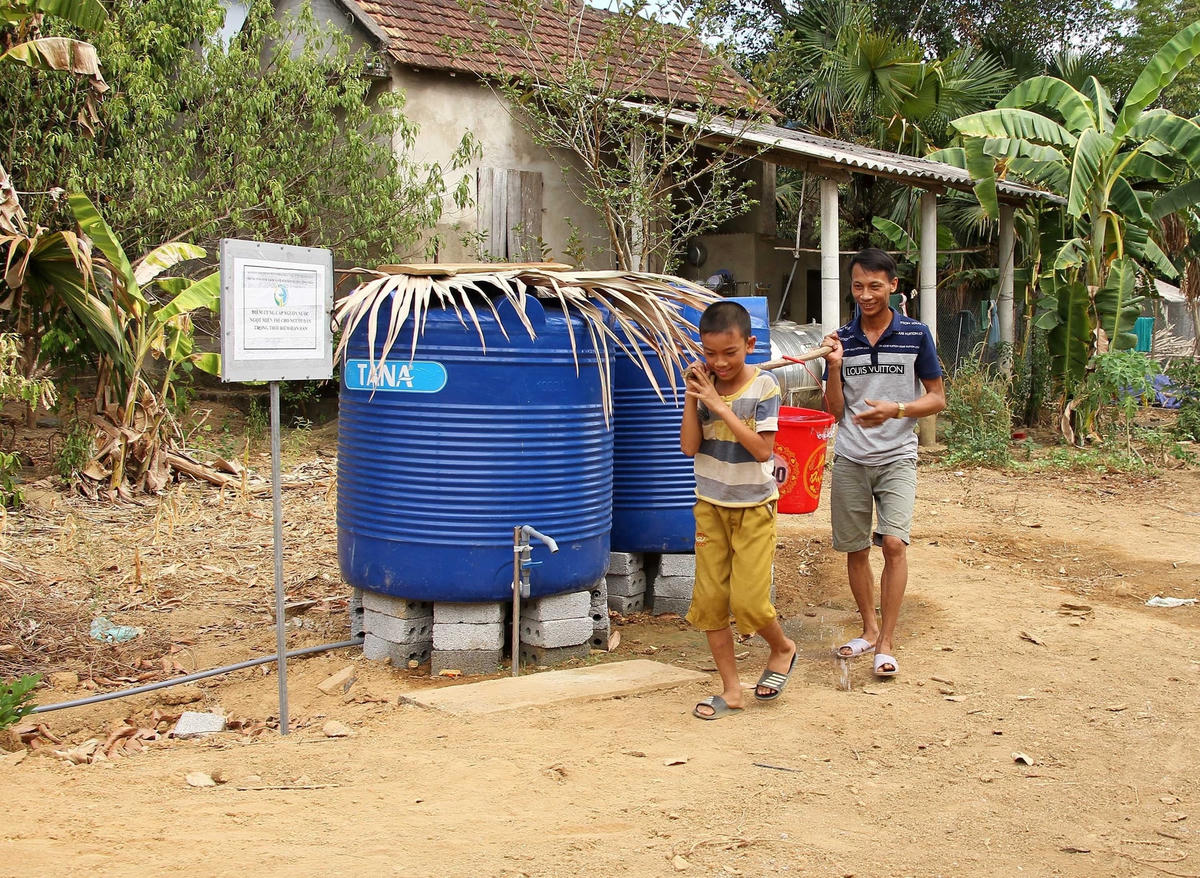Người dân đi lấy nước sạch miễn phí.