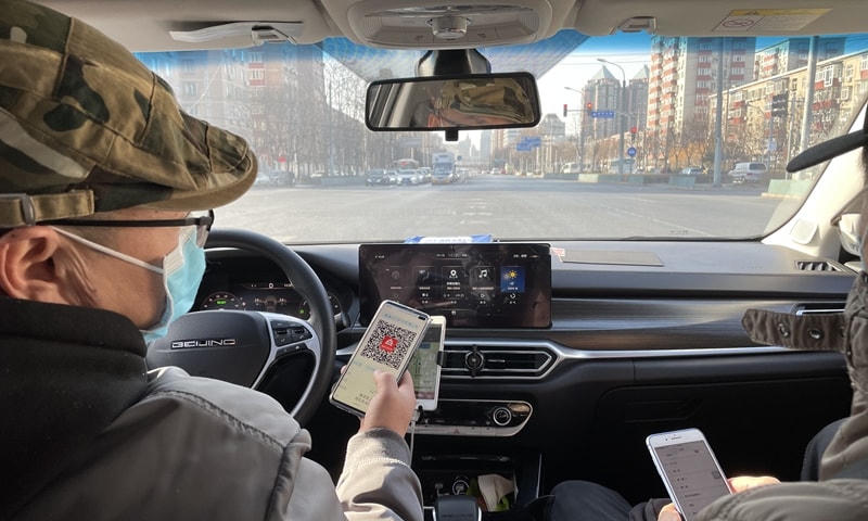 Khách đi taxi tại Bắc Kinh (Trung Quốc) thực hiện quy định quét mã QR y tế. Ảnh: GT.