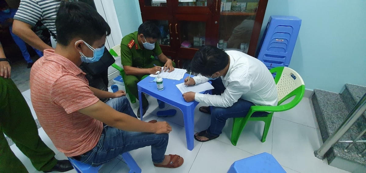 Phan Quang Hùng (áo trắng) làm việc với cơ quan chức năng. (Ảnh CTV).