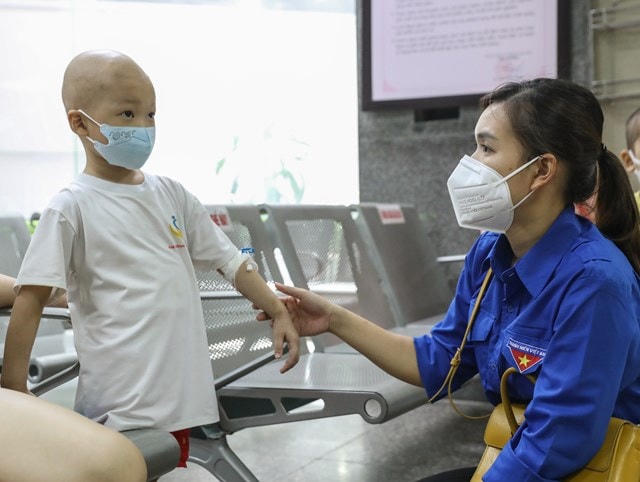 Bé Đỗ Minh Khôi lạ lẫm làm quen với các cô chú đến từ chương trình “Cơm cho người nghèo trong đại dịch Covid-19”. Ảnh: Quang Vinh.