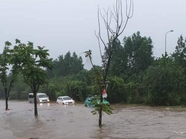 Nhiều xe ô tô cố gắng bám sát rìa đường nhưng vẫn chịu cảnh ngập sâu.