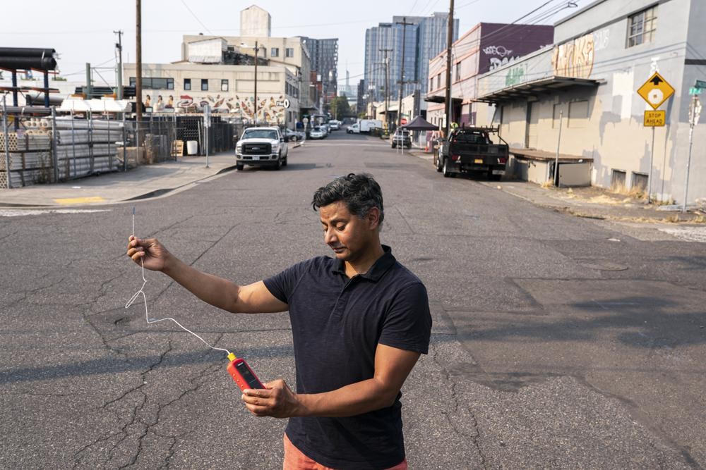 Vivek Shandas, một giáo sư về thích ứng với khí hậu tại Đại học Bang Portland, đo nhiệt độ gần 46 độ C ở trung tâm thành phố Portland vào tháng 8/2021. Ảnh: AP.