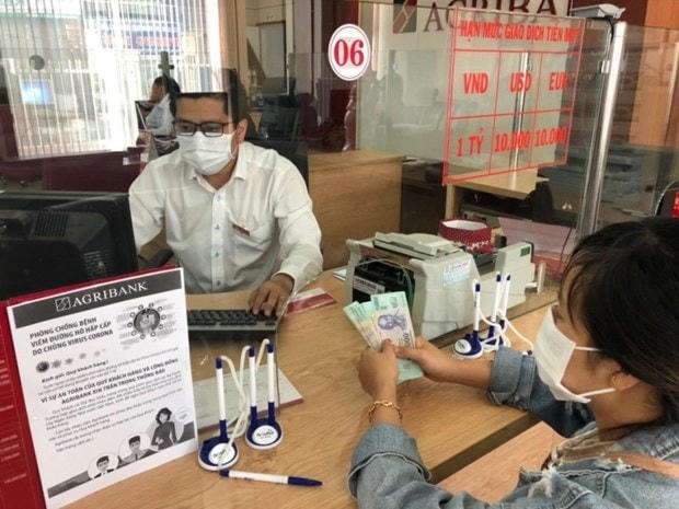 Giao dịch tại ngân hàng. (Ảnh: Vietnam+)