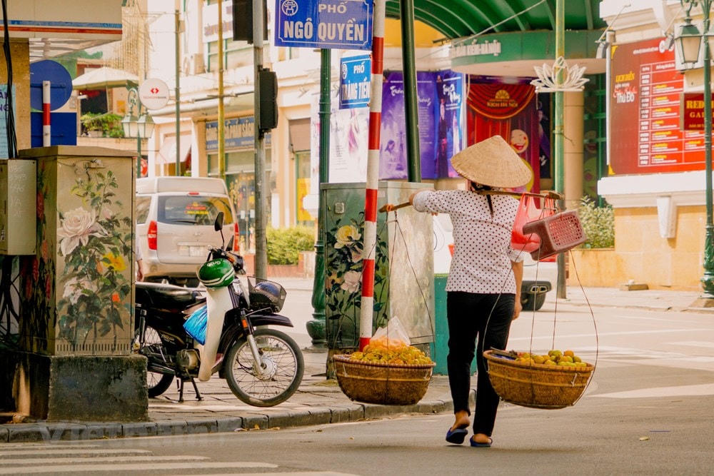 Một Hà Nội hiện đại, nhộn nhịp dường như chậm lại theo bước chân của những gánh hàng rong. (Ảnh: Minh Hiếu/Vietnam+).