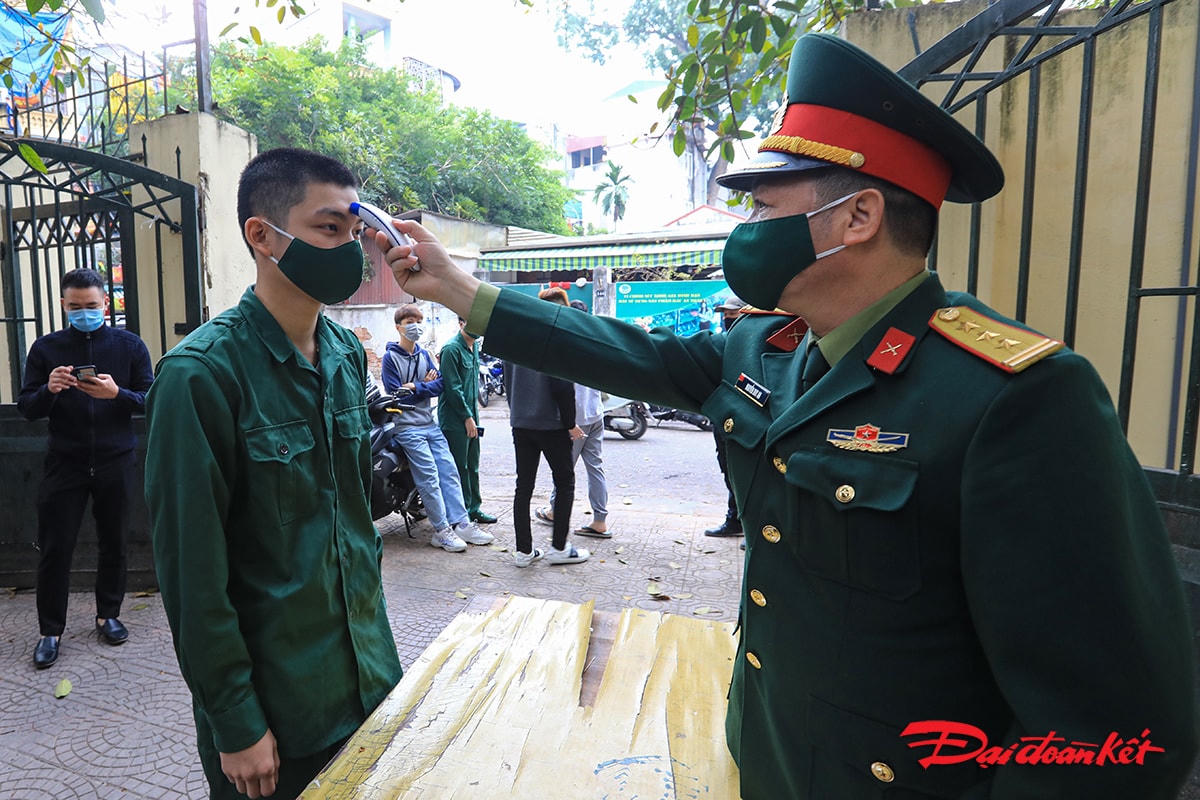 Các tân binh được kiểm tra thân nhiệt trước khi vào làm thủ tục xét nghiệm.