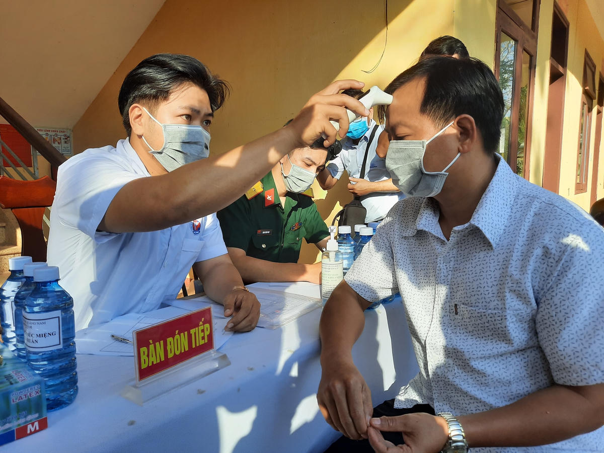 Đo thân nhiệt cho người dân.