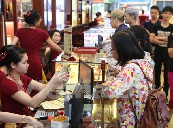 Khách hàng giao dịch vàng miếng. (Ảnh: Đức Duy/Vietnam+).