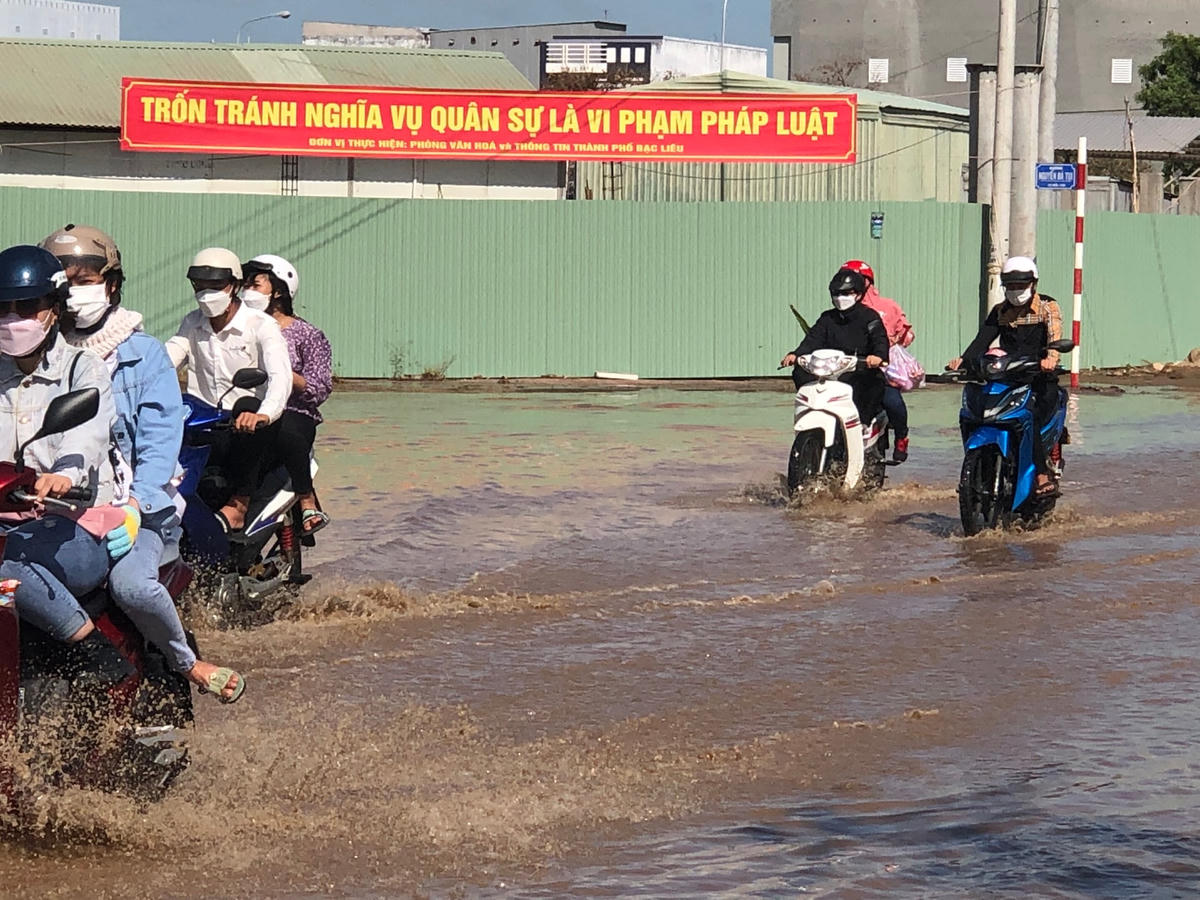 Đường Ninh Bình, phường 2, TP Bạc Liêu nhiều đoạn bị nước sông tràn qua nhấn chìm, khiến người đi đường không thể phân biệt được đâu là đường để di chuyển.