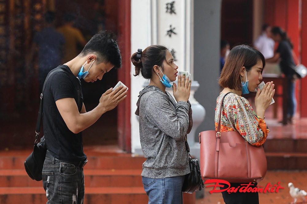 Nhiều người đeo khẩu trang nhưng lại mở ra khi hành lễ.