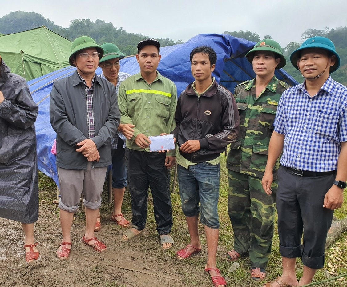 Ông Phạm Trung Đông, Chủ tịch UBND huyện Quảng Ninh tặng quà cho các hộ dân ở bản Sắt di dời để tránh thiệt hại sạt lở.