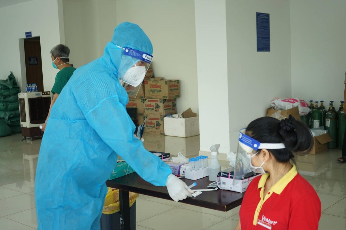 Nhân viên y tế hướng dẫn người dân tự lấy mẫu xét nghiệm. Ảnh: Diễm Hằng.