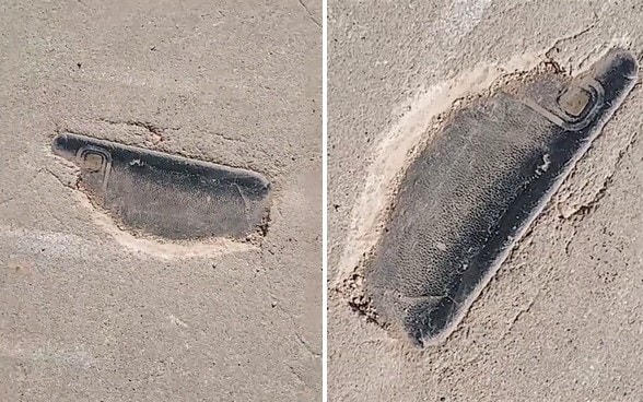 Chiếc điện thoại mà ông Thiên làm mất lộ ra dưới lớp xi măng của con đường.