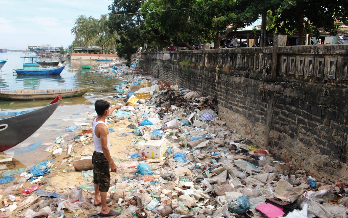Ông Lam chỉ rác thải tràn ngập bờ sông.